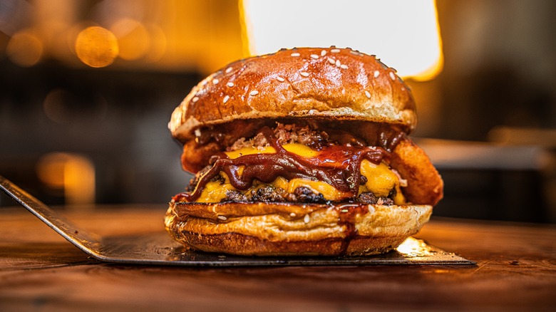 A fully prepared smash burger with onion rings