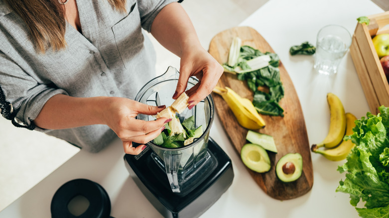Person building a smoothie