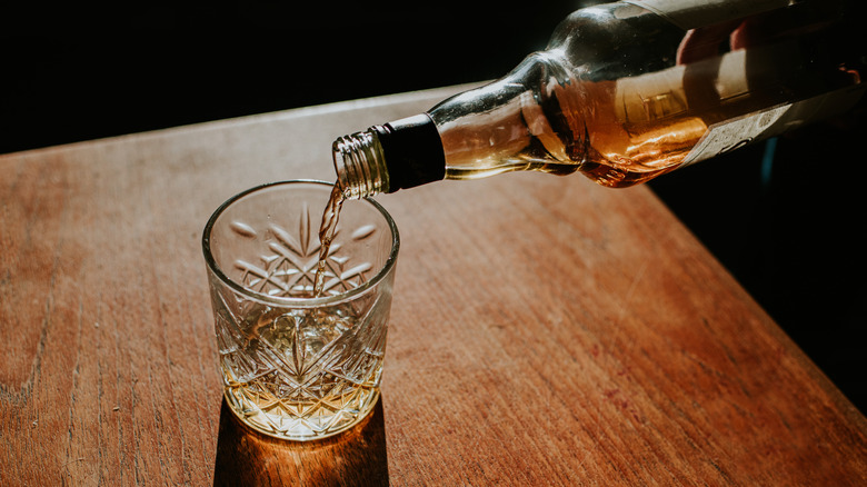 Pouring whiskey into a rocks glass