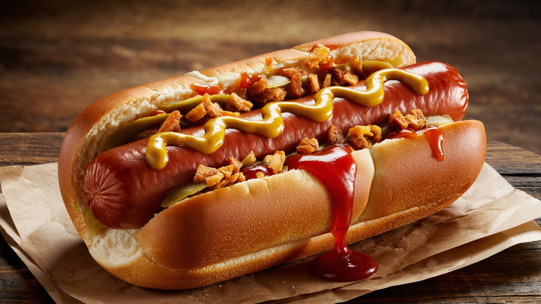 Hot dog in a bun with various toppings and sauces