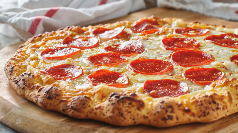 Baked pepperoni pizza on wooden board