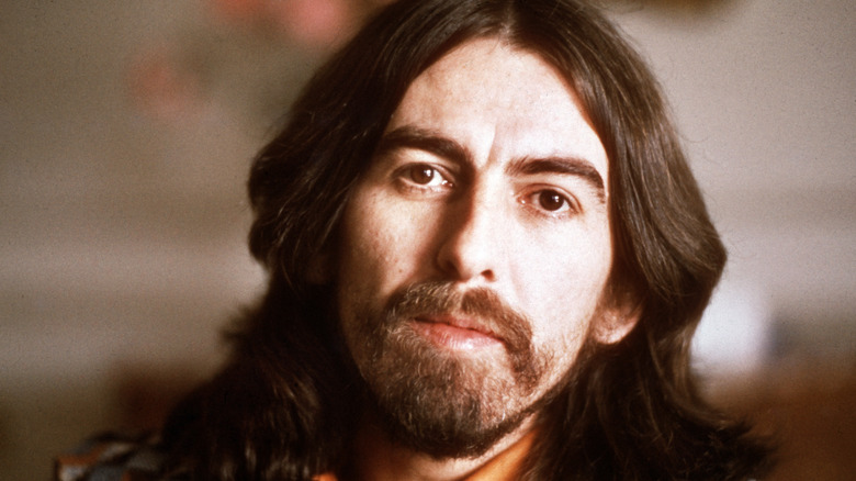 George Harrison performing on stage with guitar
